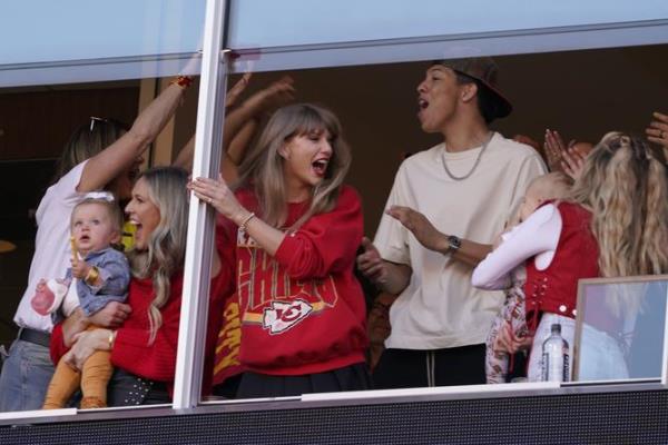 Taylor Swift celebrates as she watches from a suit during the first half of an NFL football game between the Kansas City Chiefs and the Los Angeles Chargers.