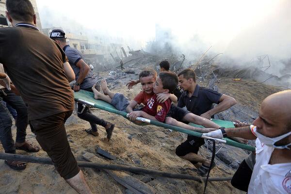 Palestinians evacuate two wounded boys out of the destruction following Israeli airstrikes on Gaza City, Wednesday, Oct. 25, 2023. Picture: AP Photo/Abed Khaled