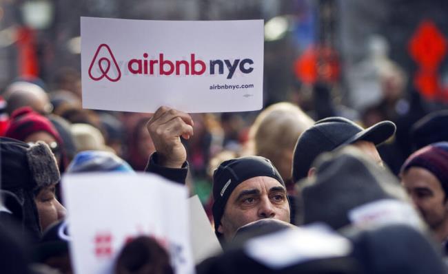 FILE — Supporters of Airbnb hold a rally outside City Hall in New York, Jan. 20, 2015. A New York judge on Tuesday, Aug. 8, 2023 dismissed lawsuits filed by Airbnb and three hosts over New York City's rules for short-term rentals, saying the restrictions are “entirely rational.” (AP Photo/Bebeto Matthews, File)