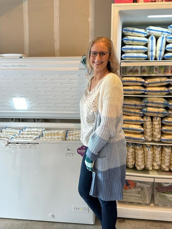 Elisabeth Anderson-Sierra stands in front of her freezers full of breast milk.