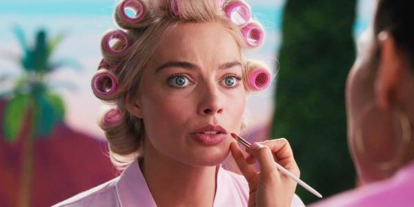 Barbie (Margot Robbie) getting her makeup done and looking worried in Barbie.